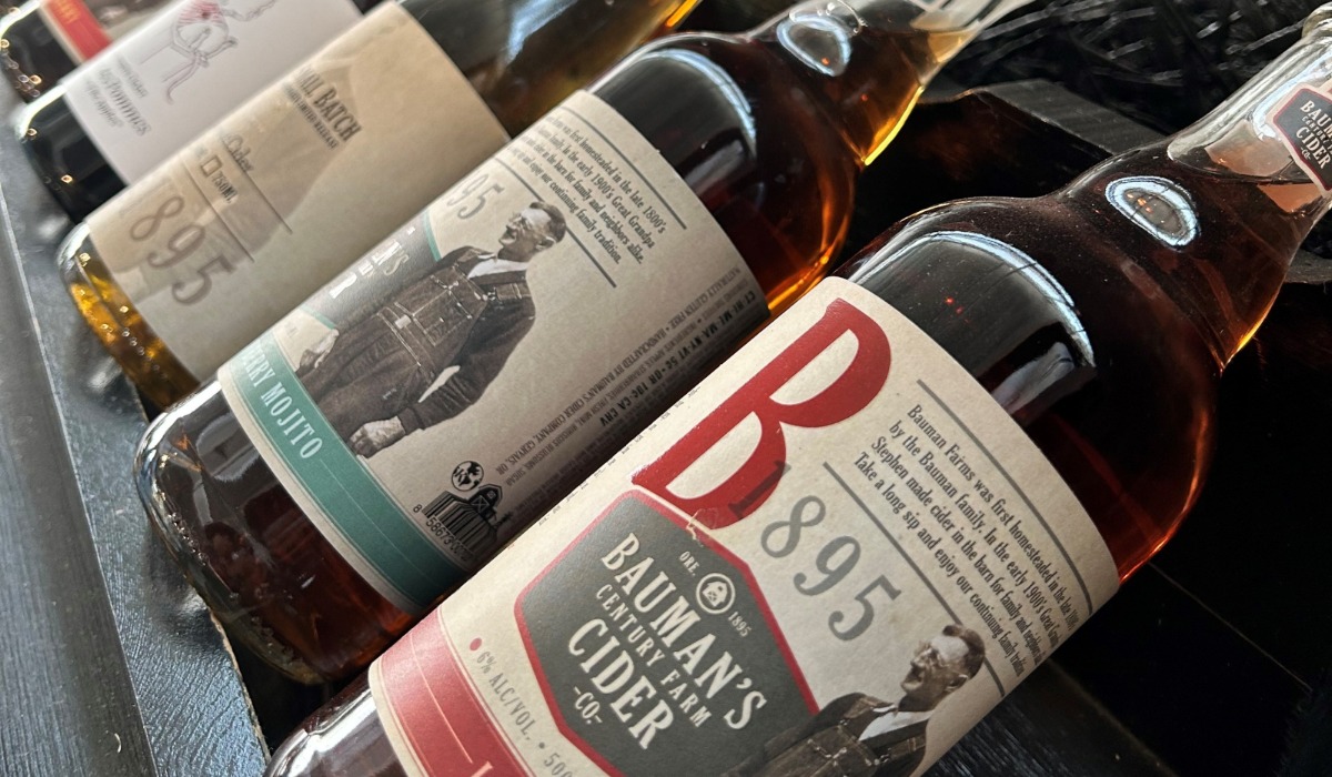 Bottles of cider lines up on shelf