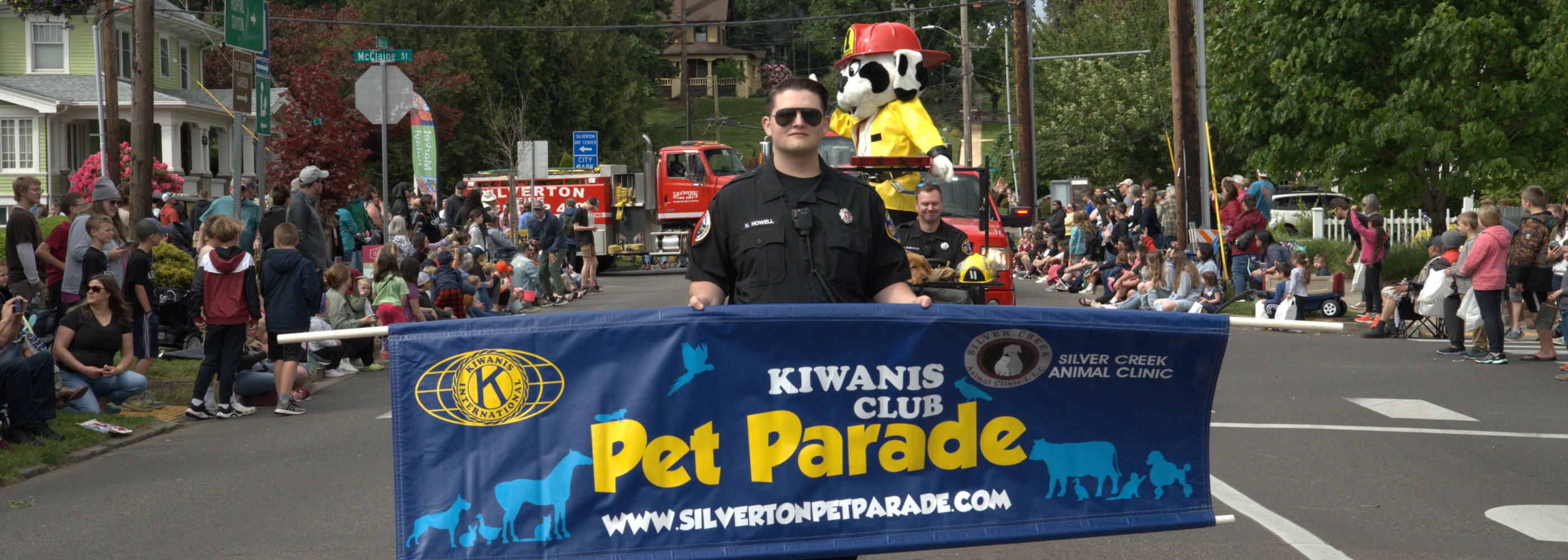 Police officer holding pet parade banner leading the parade