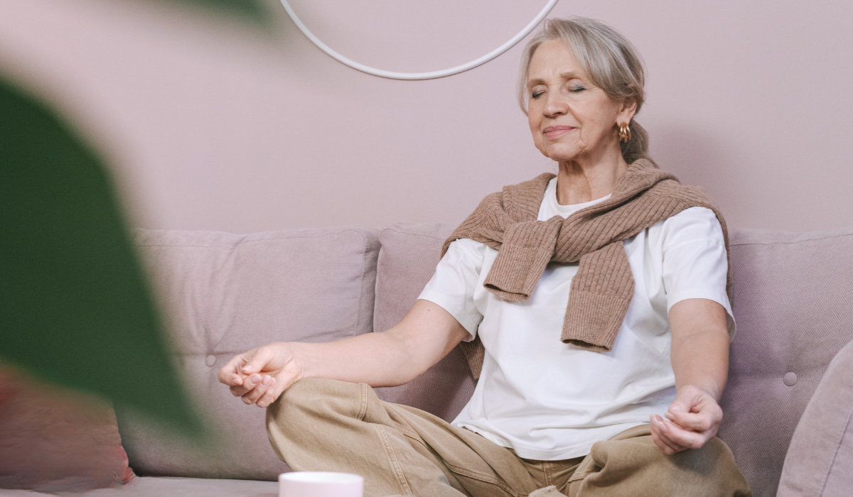 senior woman meditating on couch