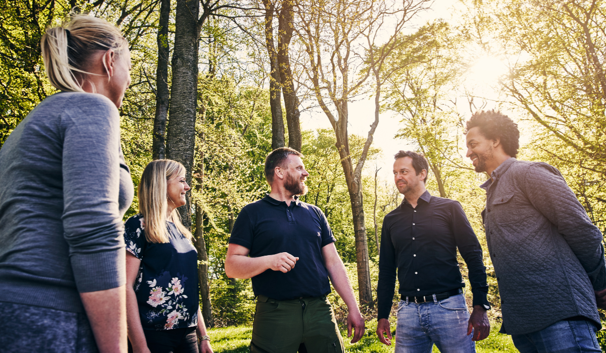 group of people outdoors talking and smiling
